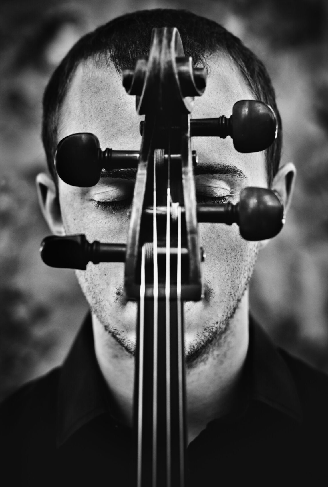 Cello scroll held before a face